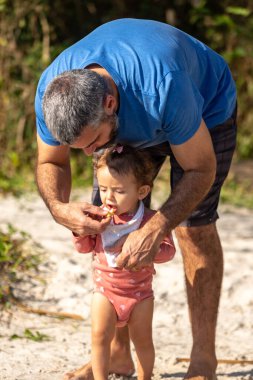 Genç beyaz bir aile güneşli bir öğleden sonra gölde piknik yapıyor..