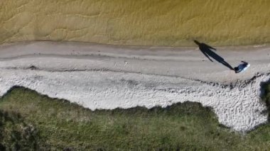 Adam yürüyor ve dışarıda koşuyor, göl kenarına park ediyor, hava manzarası var. Sağlık ve spor konsepti.