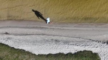 Adam yürüyor ve dışarıda koşuyor, göl kenarına park ediyor, hava manzarası var. Sağlık ve spor konsepti.