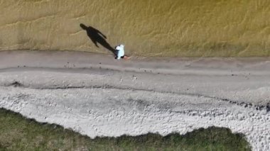 Adam yürüyor ve dışarıda koşuyor, göl kenarına park ediyor, hava manzarası var. Sağlık ve spor konsepti.