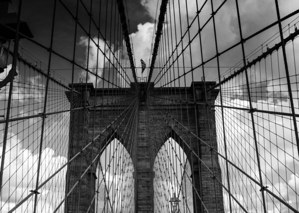 A stunning stock photo of the iconic Brooklyn Bridge, one of New York City's most popular tourist destinations. The photo captures the bridge's graceful suspension towers and its breathtaking views of the East River and the Manhattan and Brooklyn sky