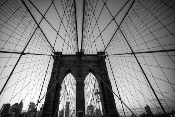 A stunning stock photo of the iconic Brooklyn Bridge, one of New York City's most popular tourist destinations. The photo captures the bridge's graceful suspension towers and its breathtaking views of the East River and the Manhattan and Brooklyn sky