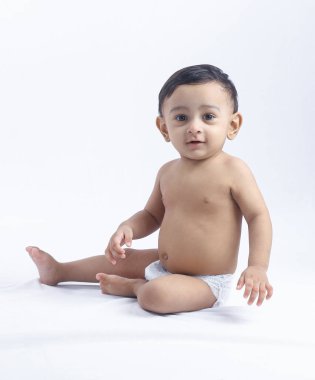 Bebek beziyle gülümseyen çocuk portresi. Parlak stüdyoda fotokopi çekerek çocuk sevincini, masumiyetini ve aile temalarını temsil ediyor..