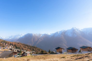 Dağda arka planda karlı tepeleri olan bir köy manzarası. Seyahat ve doğa kavramı.