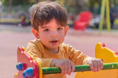 Parktaki oyun parkında oynayan küçük bir çocuk. Çocukluk kavramı.