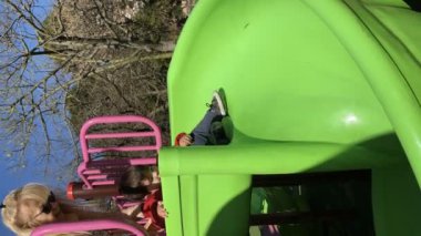 Küçük çocuk oyun parkında kayarken eğleniyor. Çocukluk kavramı.