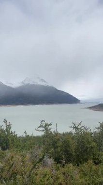 Perito Moreno Buzulu 'nun olduğu Argentino Gölü manzarası bulutlu bir günde arka planda.