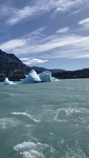 Лодка Воде Большим Айсбергом Плывущим Перед Ней Вода Спокойная Голубая — стоковое видео