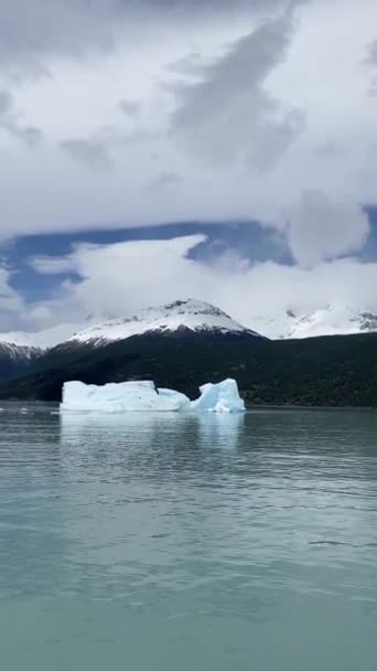 在阿根廷拉戈的一座山上 一座巨大的冰山漂浮着 天空多云 水是蓝色的 — 图库视频影像