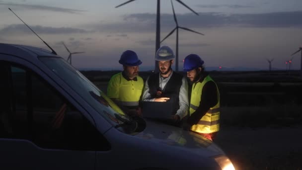 夜间在风力涡轮机农场工作 规划可再生能源生态项目的技术人员和工程师小组 — 图库视频影像