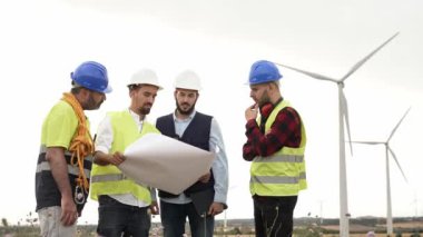 Açık havada çalışan mühendisler ve teknik işçiler rüzgar türbini tarım planlama projesiyle birlikte proje planı - Yenilenebilir Enerji Geliştirme