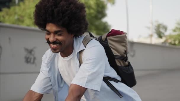 幸せなアフリカ系アメリカ人の男が市内で自転車に乗る — ストック動画