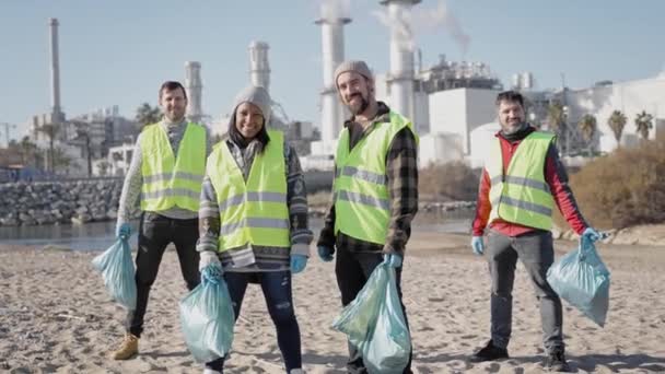 ボランティアの幸せなチームは 工業用川の海の海岸でプラスチックごみをきれいにする 汚染に対する積極的な社会的仕事 — ストック動画