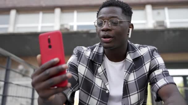 Молодой Человек Африки Использующий Мобильный Телефон Наушники Онлайн Видеозвонка — стоковое видео