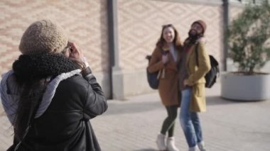 Traveling couple friends having fun posing and taking funny photo portraits in winter vacations