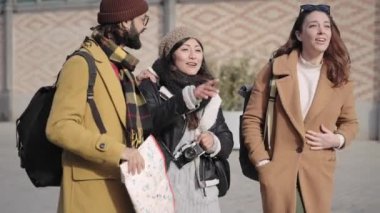 Friends visiting city and taking photos with vintage digital camera during winter trip vacations