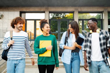 Cheerful College student friends talking and walking to University School. Diverse American Youth