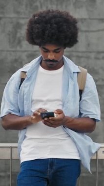 Young African American Man man using smartphone cell phone - vertical video
