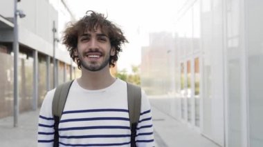 Portrait Of young Male caucasian Student with curly hair Standing In University Campus