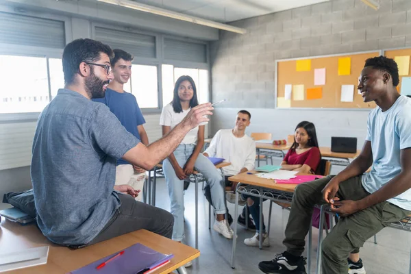 Gruppe Tenåringsstudenter Med Unge Lærere Klasserommet Som Sitter Snakker Sammen stockbilde