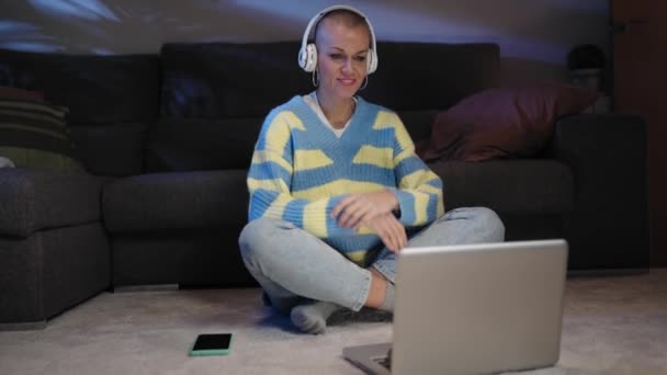 Жінка Насолоджується Переглядом Онлайн Відеофільму Своєму Ноутбуці Вночі Сидячи Килимі — стокове відео