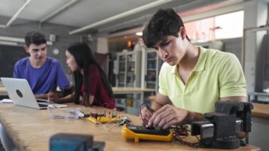 Mühendislik teknolojisi kursunda elektronik devreler inşa eden üniversite öğrencisi - Eğitimde Dijital Yenilik