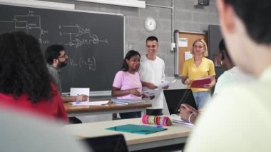 Üniversite okulundaki sınıf arkadaşlarına ve öğretmenlerine grup teknolojisi projesini sunan bir grup genç öğrenci.