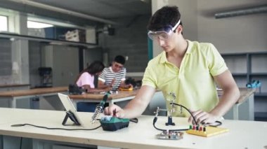 Elektronik devrede çalışan üniversite öğrencisi, robotik dersinde bilim teknolojisi öğreniyor - Eğitimde Dijital Yenilik