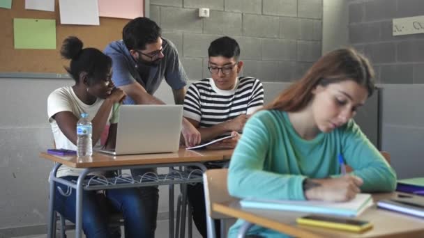 Молодой Латиноамериканец Помогает Студентам Подросткам Колледже Учится Ноутбуком Сдачи Экзаменов — стоковое видео