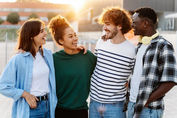 Lykkelige Multirasevenner Byen Ved Solnedgang Fire Unge Studenter Som Klemmer – stockfoto