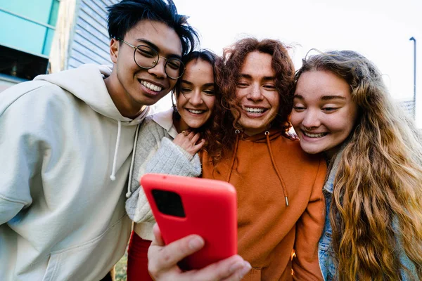 Група Студентських Друзів Які Використовують Мобільний Телефон Щоб Обмінюватися Смішним — стокове фото