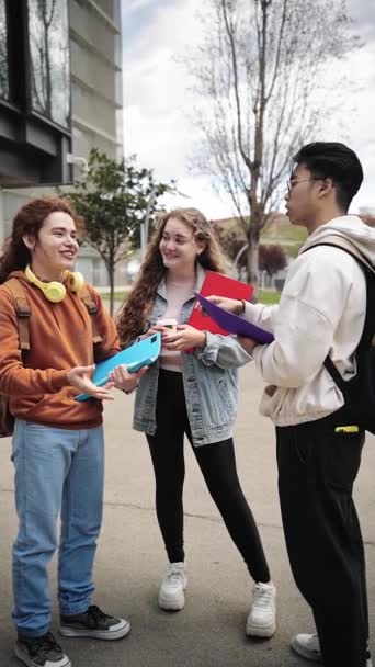若い学生の友人のグループは 大学のクラスの後に屋外にぶら下がっ 垂直ビデオ — ストック動画