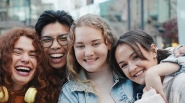 Bir grup mutlu genç Gen Z arkadaş şehirde gülümseyen kameralara bakıyor. 