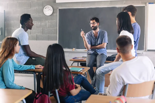 Teenager Und Junge Männliche Lehrer Tauschen Sich Der Schule Über Stockfoto