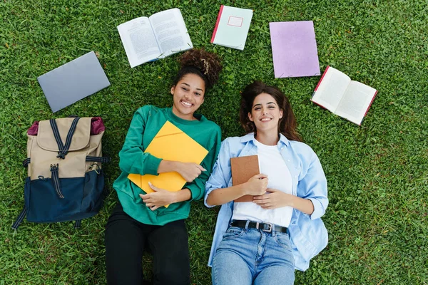 Усміхнені Студентки Університету Дівчата Підлітки Лежать Траві Кампусу Книгами Папками — стокове фото
