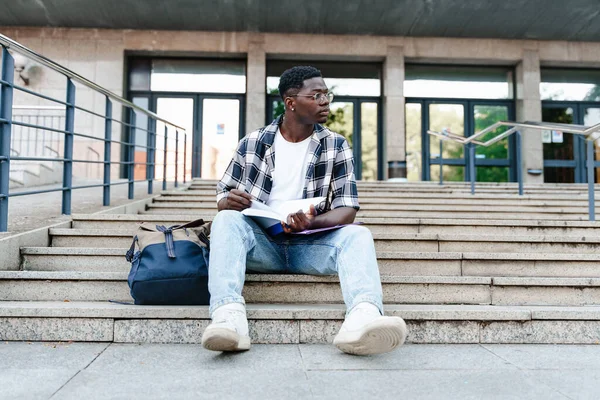 Pensive Afrikkalainen Opiskelija Käsittelyssä Kirja Istuu Yliopiston Campus Portaikko — kuvapankkivalokuva
