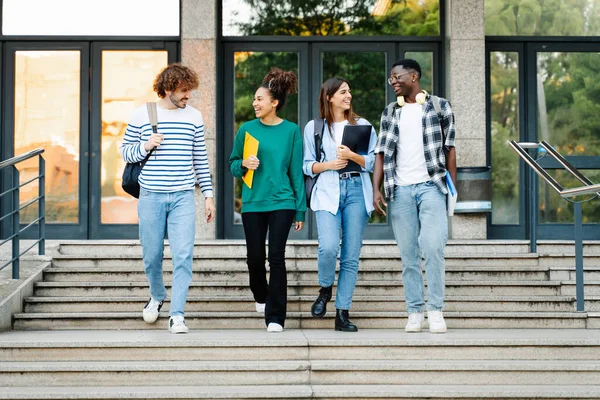 留学生の友達が大学の階段で話して歩く ロイヤリティフリーのストック写真