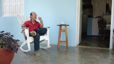Yaşlı İspanyol adam verandada dinleniyor, başka tarafa bakıyor emekli Latin Amerikalı Büyükbaba.