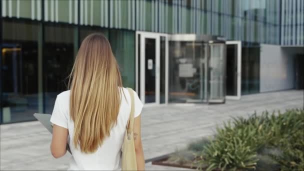 金发女学生带着书本走向大学大楼 开心地微笑着的女人看着镜头向前看 — 图库视频影像