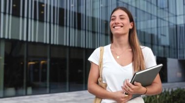 Başarılı genç sarışın kadın modern şehrin iş bölgesinde yürüyor - Öğrenci stajyerliği 