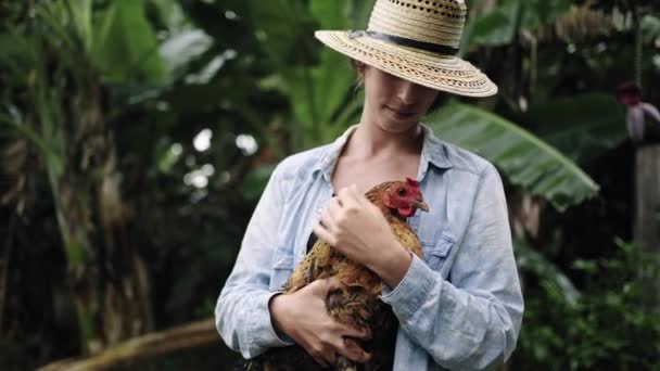 トロピカル農場でヘンを抱えている若い農夫 かわいい鶏がいる若い女性 — ストック動画
