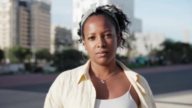 Güzel Afro-Amerikan Latin kadın portresi. Şehir caddesinde gülümseyen kameraya bakıyor.