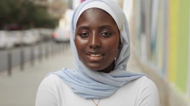 Genç gülümseyen Afrikalı kadın mavi Müslüman başörtüsü takıyor.