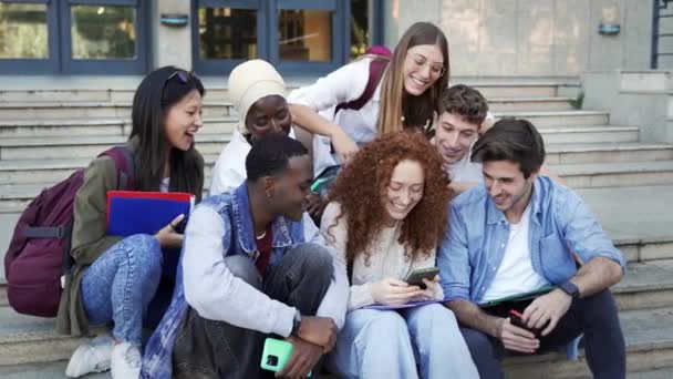 Усміхнені Студенти Університету Друзі Використовують Мобільні Пристрої Разом Переглядаючи Смішне — стокове відео