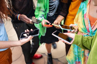 Müzik festivali sırasında cep telefonlarını ellerinde tutan bir grup modern, çeşitli tuhaf genç insan.