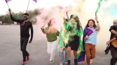 Bir grup insan ellerinde gökkuşağı bayraklarıyla sokaklarda dans ediyor, renkli dumanlarla gay onur festivalinin tadını çıkarıyorlar.