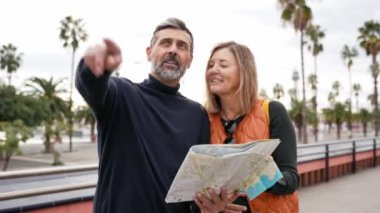 Turist çift şehir caddesinde harita arayarak gezinin tadını çıkarıyor.