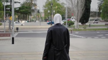 Şehirde yürüyen başörtüsü takan modern müslüman kadın gülümseyen Z Nesli Afrikalı Kız