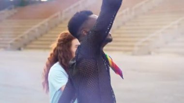 Arkadaşlarıyla dans eden Afrikalı adam gay gökkuşağı bayraklarıyla dans eden gay onur festivalini kutluyor 