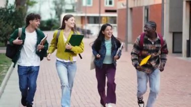 Kampüste koşan bir grup öğrenci üniversite mezuniyetini kutlamak için üniversiteye gidiyorlar.